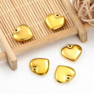 Pendentifs cœurs dorés en acier inoxydable pour bijoux DIY sur plateau en bambou