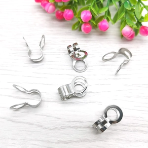 Macro detail of polished stainless steel jewelry connectors on a wooden background