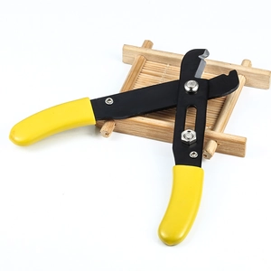 Stainless steel heavy chain plier and wire stripper with ergonomic yellow handles on wood