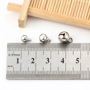Hollow stainless steel bells in three sizes shown with a ruler for scale measurement