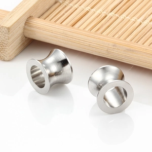 Polierte silberne Fleischtunnel aus Edelstahl mit Double Flared Design auf Holz