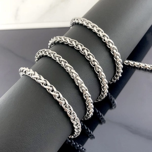 Gepolijste zilveren roestvrijstalen spiga ketting met fijn geweven textuur op display