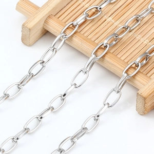 Cadena de acero inoxidable pulido con eslabones ovales sobre bandeja de bambú