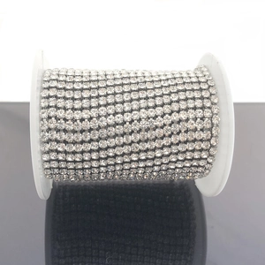 Detailopname van sprankelende strass-cupketting op een spoel voor DIY-sieraden