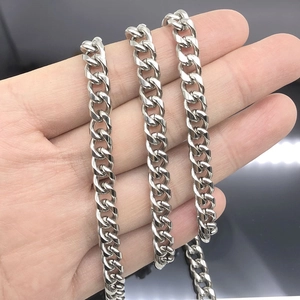 Polished silver stainless steel Cuban link chain necklace held by hand showing texture