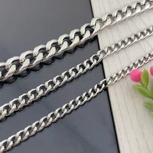 Polished silver stainless steel Cuban link chains in three different sizes on dark background