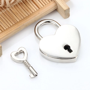 Lucchetto a cuore in argento lucido con chiave su un vassoio di legno minimalista