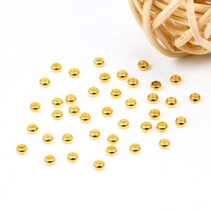 Golden stainless steel crimp beads for DIY jewelry making scattered on white background