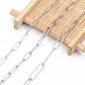 Detailed close-up of polished silver stainless steel paperclip chains on a bamboo tray