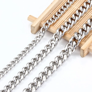 Detailed comparison of three polished stainless steel Cuban link chains on a bamboo display
