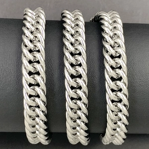 Detail view of silver stainless steel flat curb link chains on black display stand