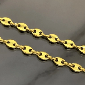 Polished gold coffee bean link chain made of stainless steel on a sleek black background