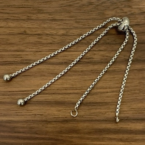 Zilveren verstelbare schuifketting voor DIY-sieraden maken op donkerhouten ondergrond