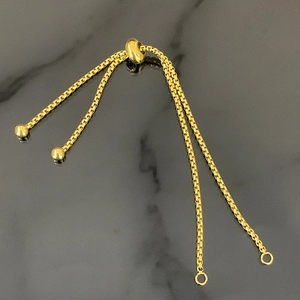 Detail van verstelbare gouden box chain armband met schuifkraal en gepolijste afwerking