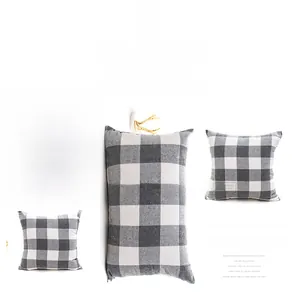Gros plan du tissu à carreaux gris sur une housse de coussin en coton et polyester