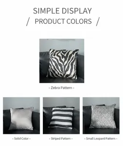 Détail de housses de coussin à rayures et motifs sur un canapé en cuir noir