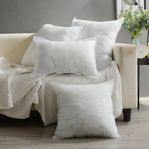 Set aus weißen quadratischen und rechteckigen Kissenfüllungen auf einem Sofa im Wohnzimmer