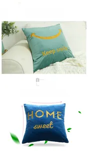 Detail of emerald and royal blue velvet pillow covers with golden embroidered slogans