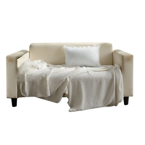 Cremefarbene Strickdecke mit vertikalem Rippmuster auf einem hellgrauen Sofa für Dekoration