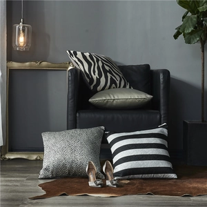 Moderne Kissenbezüge mit Streifen und Tiermustern auf einem luxuriösen Sofa im Zimmer