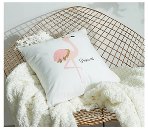 Detail of white throw pillow featuring a pink flamingo with gold sequins and Princess text