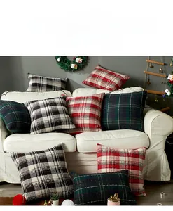 Detail of Christmas plaid knitted pillowcase on a cozy white sofa with festive decor