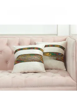Ethnic style velvet cushion covers with colorful geometric ribbons on pink sofa