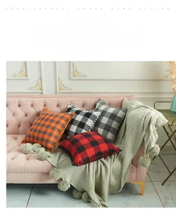 Detail of plaid cotton-polyester pillowcase featuring colorful pom-pom decorative edges