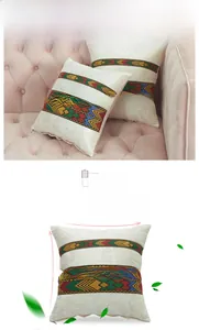 Detailed view of ethnic embroidery on cream velvet cushion cover with colorful geometric patterns