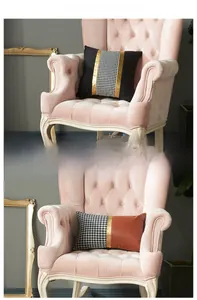Detail of modern velvet throw pillow featuring houndstooth pattern and golden satin patchwork