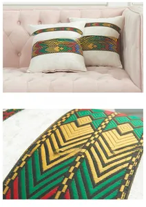 Close-up of ethnic geometric embroidery on cream velvet decorative cushion cover