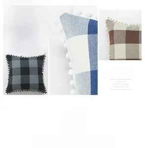 Detail of plaid linen pillow covers with decorative pom-pom fringe in multiple colors
