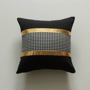 Modern black cushion cover featuring houndstooth pattern and gold metallic trim