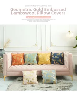 Detail of lamb wool pillow covers with geometric gold foil patterns on a velvet sofa