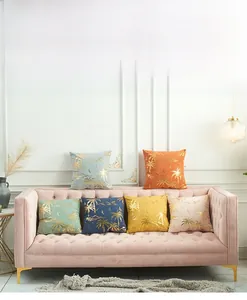 Detailed view of six lamb velvet pillow covers with golden palm tree prints on a sofa