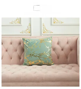 Detail of mint green lamb velvet pillowcase with gold geometric patterns on a sofa