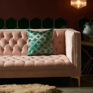 Modern emerald green Art Deco shell pattern cushion cover on a pink velvet sofa