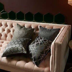 Modern decorative square pillow covers with geometric and floral patterns on velvet sofa