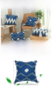 Gros plan sur la housse de coussin géométrique bleue avec motifs vagues et glands décoratifs