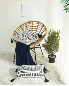 Detail of chenille pillow covers with geometric patterns and black corner tassels