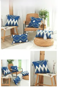 Détail de housses de coussin nordiques avec broderie tuftée, motifs géo et pompons