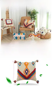 Détail de la housse de coussin bohème avec pompons colorés et motifs géométriques