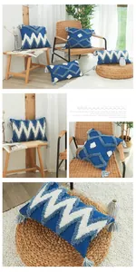 Gros plan des motifs géométriques touffetés et des pompons sur une housse de coussin bleue