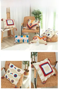 Détail du motif géométrique touffeté et glands colorés sur la housse de coussin en coton