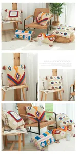 Détail d'une housse de coussin en coton bohème avec motifs touffetés colorés et glands