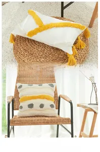 Detailed texture of bohemian cotton tufted cushion covers with tassels and yellow embroidery