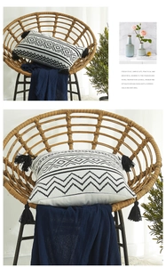 Close-up of bohemian geometric patterns and black tassels on chenille pillow cover
