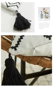 Detail of bohemian white cushion cover with black tassels and hidden zipper closure