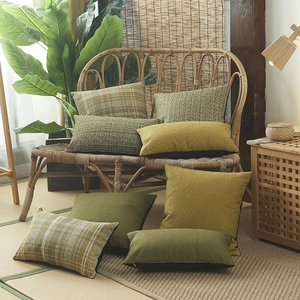 Housses de coussin en lin à carreaux vert et jaune sur un canapé en rotin