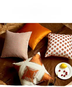 Detailed view of mixed texture pillow covers including orange velvet and polka dots